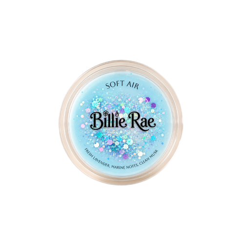 A round plastic container of Billie Rae Soft Air glitter, featuring a light blue translucent base filled with multicolored holographic glitter and lavender flower confetti, on a solid white background.