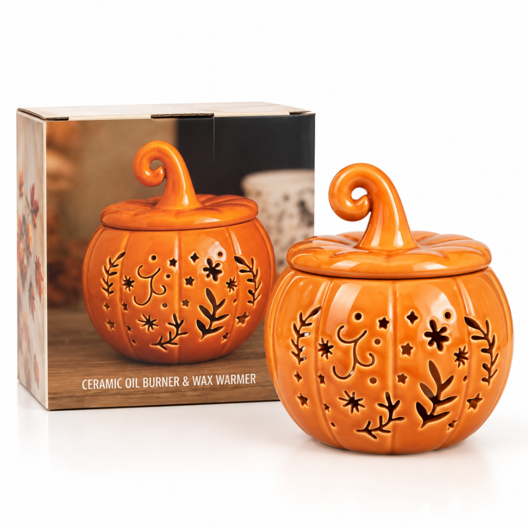 An orange pumpkin-shaped ceramic oil burner and wax warmer with a lid, shown in front of its product box on a white background.