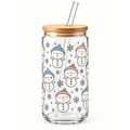 A clear glass tumbler with a bamboo lid and glass straw, decorated with a repeating pattern of smiling snowmen wearing colorful knit hats and small snowflakes.