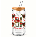 A clear glass tumbler with a bamboo lid and clear glass straw, decorated with a Christmas nutcracker and bow pattern and the text 'Merry Christmas' in red script.